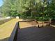 View from wood deck overlooking a spacious, green backyard with a wooden fence and plenty of trees at 607 Wahlbrink Dr, Wake Forest, NC 27587