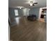 Open-concept living room with updated flooring, ceiling fans, a sofa, and access to dining and entry areas at 607 Wahlbrink Dr, Wake Forest, NC 27587