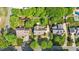 Aerial view of homes with lush greenery, a basketball court, manicured lawns, and mature trees at 608 Driftwood Dr, Gibsonville, NC 27249