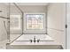 A soaking tub under a decorative window adjacent to the stand-up shower at 608 Driftwood Dr, Gibsonville, NC 27249