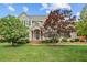 Charming two-story home with a manicured lawn, mature trees, and a welcoming brick entrance at 608 Driftwood Dr, Gibsonville, NC 27249