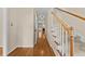 Hallway with hardwood flooring and stairs with white railing at 608 Driftwood Dr, Gibsonville, NC 27249