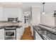 Well-lit kitchen with stainless steel appliances, white cabinets, and granite countertops at 608 Driftwood Dr, Gibsonville, NC 27249