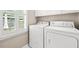 Bright laundry area with modern washer/dryer appliances and extra upper storage cabinets at 608 Driftwood Dr, Gibsonville, NC 27249