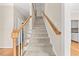 Carpeted stairway with wood handrail and white decorative wood risers at 608 Driftwood Dr, Gibsonville, NC 27249