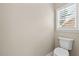 Powder room featuring white toilet and privacy window with plantation shutters at 608 Driftwood Dr, Gibsonville, NC 27249