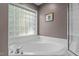Bathroom featuring soaking tub with tile surround and patterned glass window at 612 Lakeview Ave, Wake Forest, NC 27587