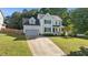 Charming two-story home featuring a long driveway, attached garage, manicured lawn, and welcoming front porch at 612 Lakeview Ave, Wake Forest, NC 27587