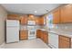 Well-lit kitchen featuring granite countertops, wood cabinets, and modern white appliances at 612 Lakeview Ave, Wake Forest, NC 27587