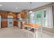 Bright kitchen featuring white appliances, wood cabinets, tile backsplash, and an eat-in dining table at 612 Lakeview Ave, Wake Forest, NC 27587