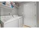 Bright laundry room with white washer and dryer and storage shelving at 612 Lakeview Ave, Wake Forest, NC 27587