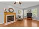 Comfortable living room with a fireplace, hardwood floors, bright windows, and a ceiling fan at 612 Lakeview Ave, Wake Forest, NC 27587