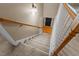 Carpeted staircase with wooden banister leading to the front door and main level of the home at 612 Lakeview Ave, Wake Forest, NC 27587