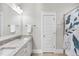 Bathroom with granite countertop vanity, large mirror, and shower with curtain, offering a blend of style and functionality at 707 Sasser St, Raleigh, NC 27604
