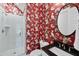 Bathroom featuring decorative red wallpaper, a black granite counter and a white glass shower at 707 Sasser St, Raleigh, NC 27604