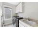 Well-lit laundry room equipped with modern appliances, practical storage cabinets, and a sink for added convenience at 707 Sasser St, Raleigh, NC 27604