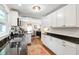 Charming kitchen featuring white cabinets, dark countertops, hardwood floors, and stainless steel appliances with ample lighting at 713 E Whitaker Mill Rd, Raleigh, NC 27608