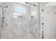 Gorgeous glass shower with white marble-style tile and a built-in shower caddy at 713 E Whitaker Mill Rd, Raleigh, NC 27608