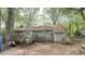 Back exterior of a cozy home with a wooden deck, green siding, surrounded by lush greenery and mature trees at 7312 Ray Rd, Raleigh, NC 27613