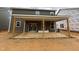 Covered back porch, perfect for outdoor entertaining, with wood supports and sliding glass door access at 776 Old Station Pointe, Angier, NC 27501