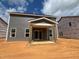 Back of house with covered patio under construction, showing sliding glass doors and yard space at 776 Old Station Pointe, Angier, NC 27501