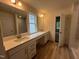 Bright bathroom featuring double sinks, white cabinets, modern fixtures, and wood look flooring at 776 Old Station Pointe, Angier, NC 27501
