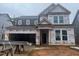 New two-story home featuring an attached two-car garage and covered entryway, still under construction at 776 Old Station Pointe, Angier, NC 27501