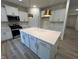 Bright kitchen features white cabinets, stainless appliances, pendant lighting and an island with seating at 776 Old Station Pointe, Angier, NC 27501