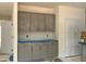 Grey lower and upper cabinets with hardware, covered in plastic with doors on either side of the space at 776 Old Station Pointe, Angier, NC 27501