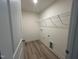 Laundry room with wood-look floors, washer/dryer hookups and storage shelf at 776 Old Station Pointe, Angier, NC 27501