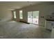 Open-concept living area with multiple windows and sliding glass doors leading to outdoor space and kitchenette at 776 Old Station Pointe, Angier, NC 27501