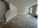 Spacious living room featuring staircase, neutral walls, and ample natural light from the large window at 776 Old Station Pointe, Angier, NC 27501