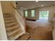 This living room has large windows, a staircase, and a sliding glass door to the back patio at 776 Old Station Pointe, Angier, NC 27501