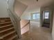 Stairway with unfinished wood and a view of the living room with windows and white walls at 776 Old Station Pointe, Angier, NC 27501