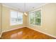 Dining room with hardwood floors, modern chandelier, and two large windows with blinds at 8231 Allyns Landing Way # 302, Raleigh, NC 27615