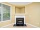 Living room featuring a modern gas fireplace with a white mantel, tan walls, and blinds at 8231 Allyns Landing Way # 302, Raleigh, NC 27615