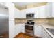 Kitchen with stainless steel appliances, white cabinets, hardwood floors, and light countertops at 8231 Allyns Landing Way # 302, Raleigh, NC 27615