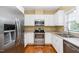 Kitchen with stainless steel appliances, white cabinets, hardwood floors, and a stainless refrigerator at 8231 Allyns Landing Way # 302, Raleigh, NC 27615