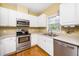 Kitchen with stainless steel appliances, white cabinets, hardwood floors, and a window at 8231 Allyns Landing Way # 302, Raleigh, NC 27615