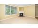 Living room featuring a gas fireplace, large window, and tan walls and carpet at 8231 Allyns Landing Way # 302, Raleigh, NC 27615