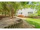 A beautiful backyard with a stone patio, fire pit, wood deck, and lush green lawn provides an ideal outdoor living space at 8814 Waynick Dr, Raleigh, NC 27617