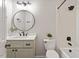 Stylish bathroom with a modern vanity, round mirror, and a shower-tub combination at 8814 Waynick Dr, Raleigh, NC 27617