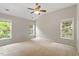 Bedroom with three windows, ceiling fan, neutral carpet and paint, and double closet at 8814 Waynick Dr, Raleigh, NC 27617