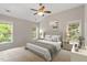 Staged bedroom with two windows, ceiling fan, neutral carpet and paint, with a queen size bed at 8814 Waynick Dr, Raleigh, NC 27617