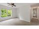 Bright bedroom with a large window overlooking greenery and plush carpeting at 8814 Waynick Dr, Raleigh, NC 27617