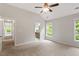 Bedroom with ceiling fan, two windows, neutral carpet and paint, and an ensuite bathroom at 8814 Waynick Dr, Raleigh, NC 27617