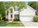 Charming two-story home with white siding, black shutters, landscaped yard, and attached two-car garage at 8814 Waynick Dr, Raleigh, NC 27617