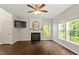 Cozy living room features a fireplace, large TV, ceiling fan and multiple windows overlooking greenery at 8814 Waynick Dr, Raleigh, NC 27617