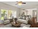 Bright living room featuring large windows, ceiling fan, and stylish furniture open to the kitchen at 8814 Waynick Dr, Raleigh, NC 27617