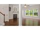 Living room featuring a fireplace, hardwood floors, ceiling fan, and large windows overlooking greenery at 8814 Waynick Dr, Raleigh, NC 27617